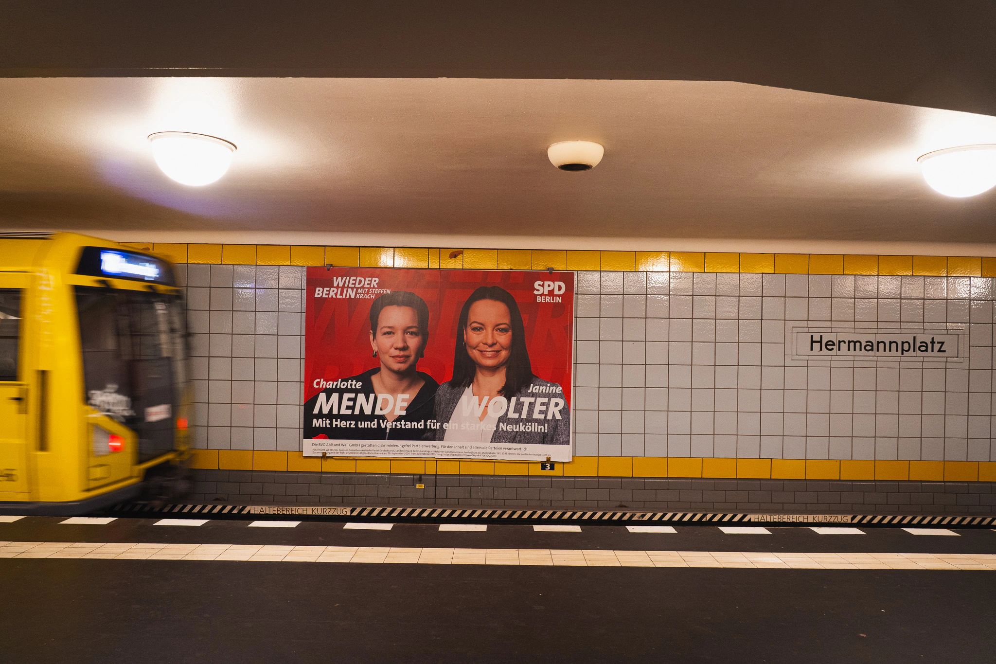 Yellow U-Bahn train pulling into Hermannplatz station