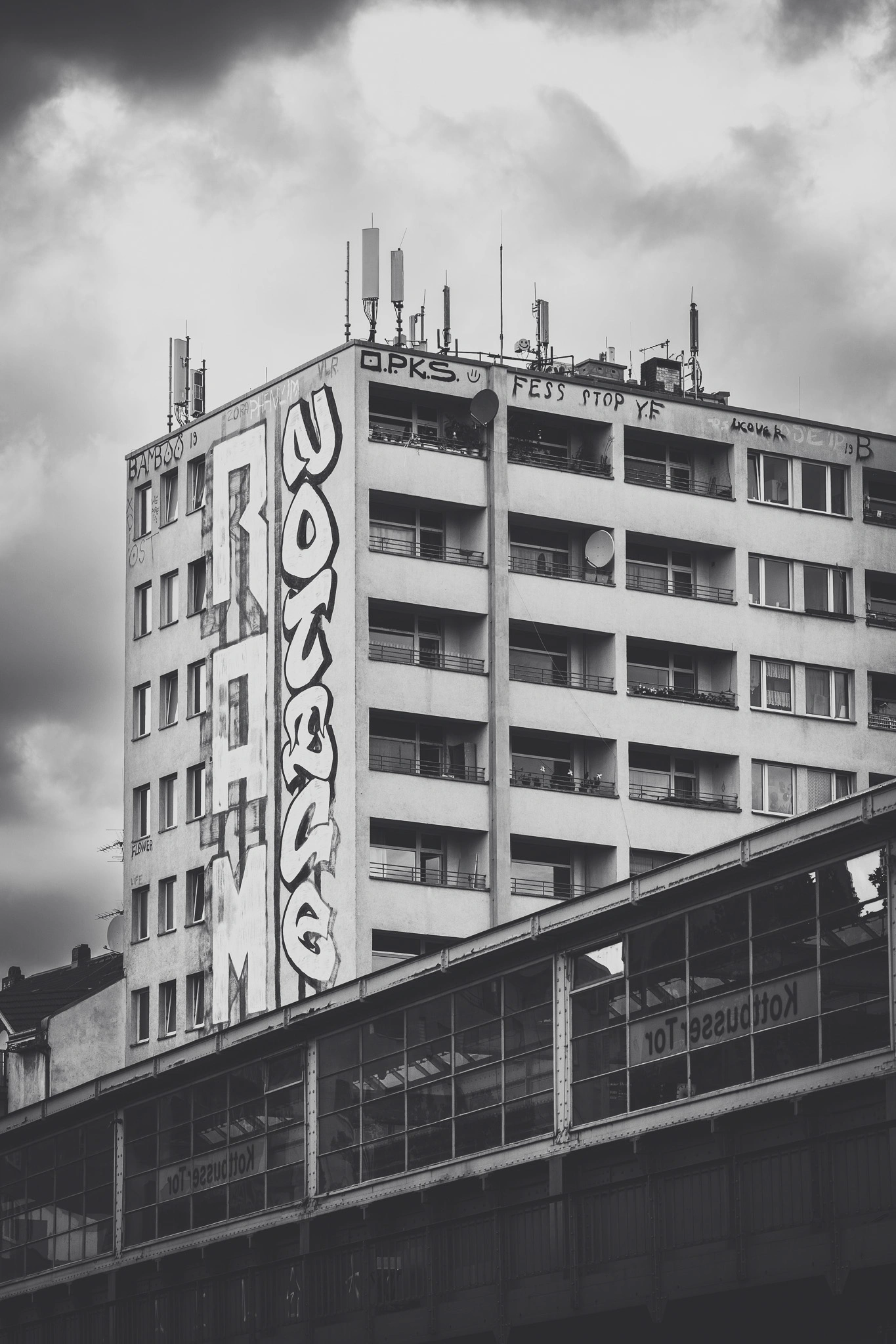 Graffiti-covered high-rise above the U-Bahn viaduct at Kottbusser Tor, black and white