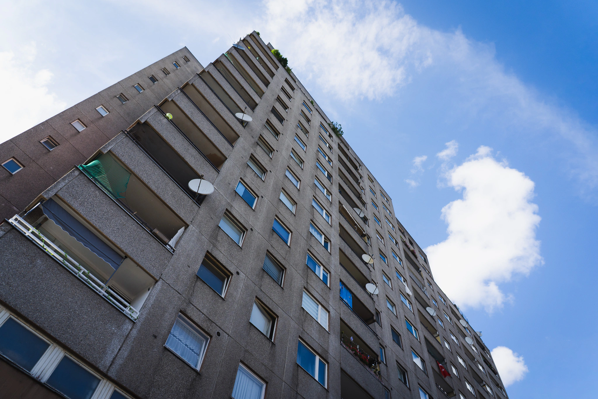 Looking up a concrete tower block against a blue summer sky
