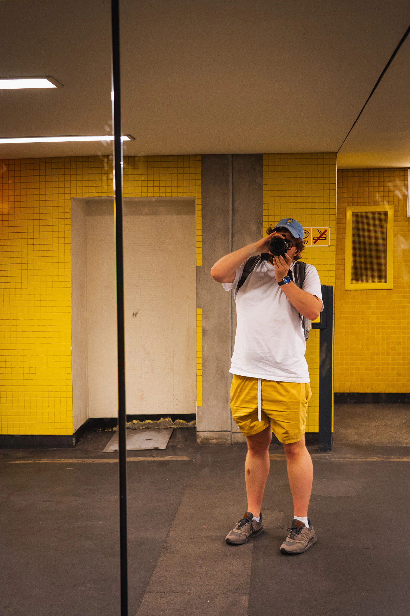 Mirror self-portrait on the yellow-tiled platform at Zoologischer Garten