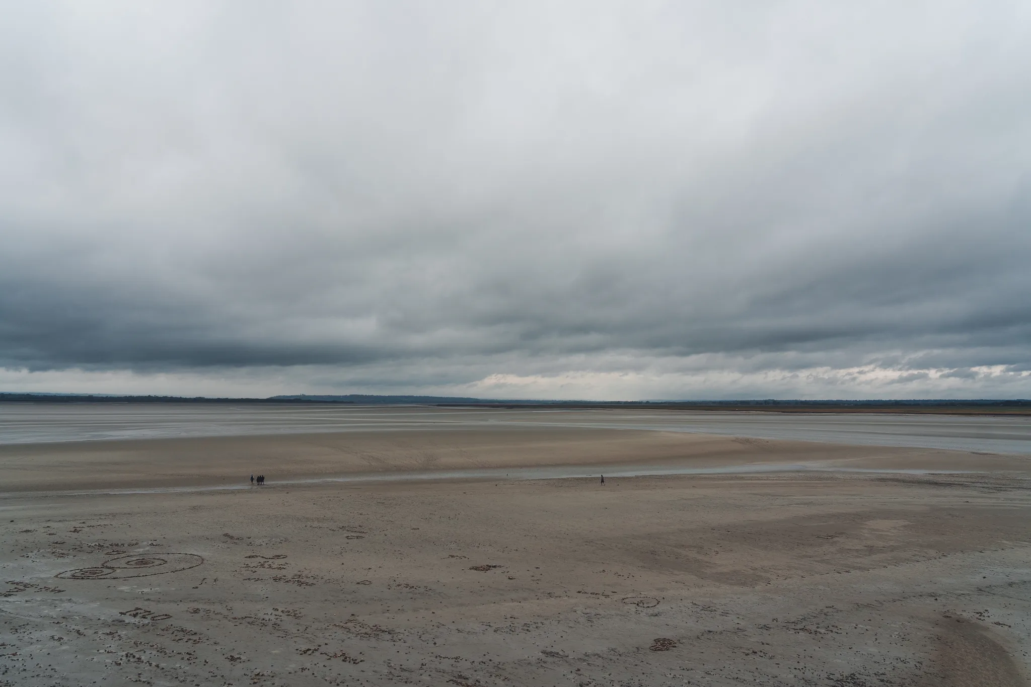 Brown sand flats with a few distant figures